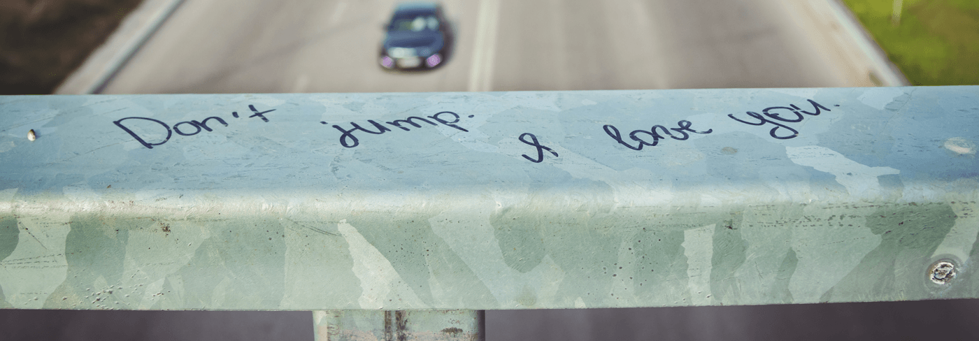 Don't Jump Written On Bridge Railing Overlooking Highway